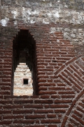 Blick durch den Fensterauschnitt einer Ruine auf einen weiteren Fensterausschnitt